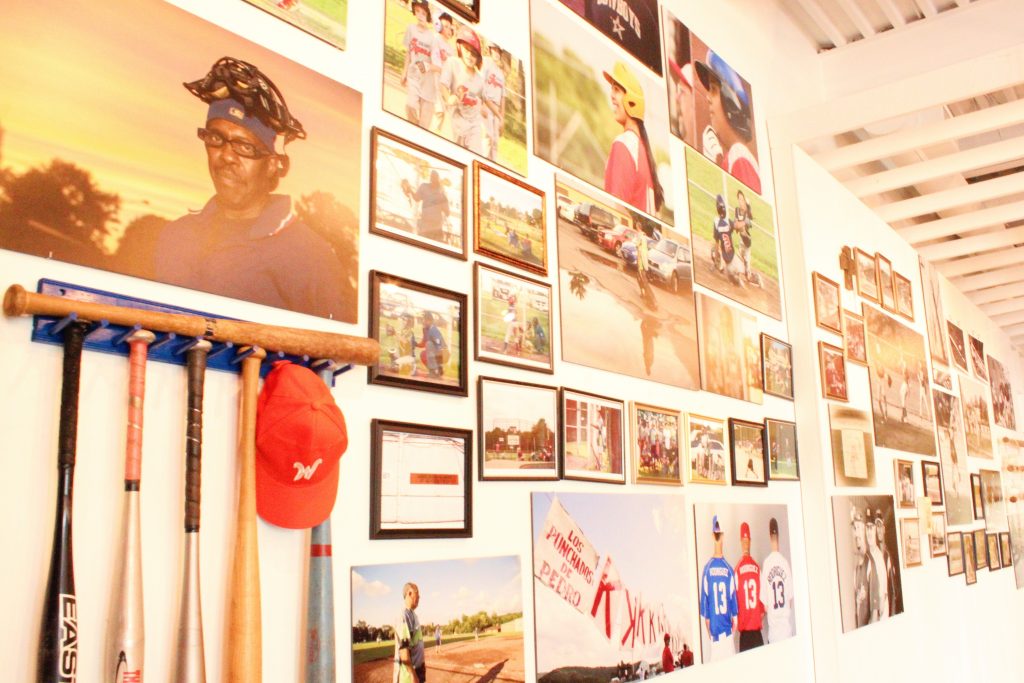 Baseball bats and old photos on a wall.